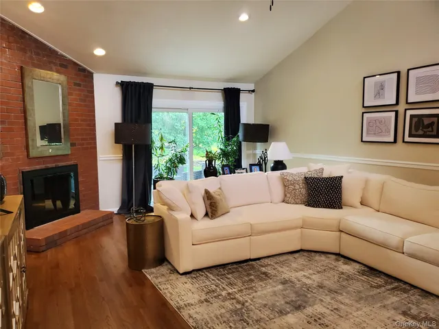 a living room with furniture fireplace and a large window