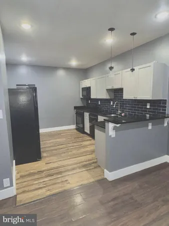 a large white kitchen with a sink and dishwasher