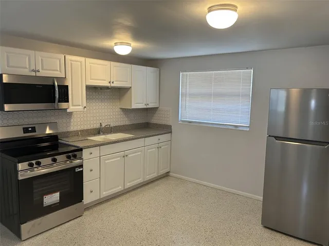 a kitchen with stainless steel appliances granite countertop a refrigerator stove a sink and dishwasher