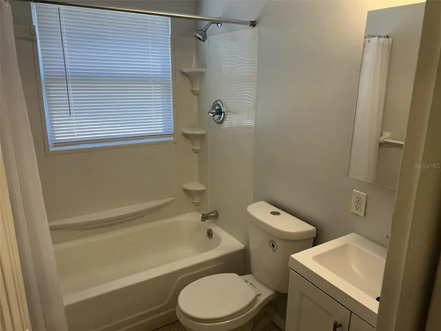 a white toilet and a shower curtain