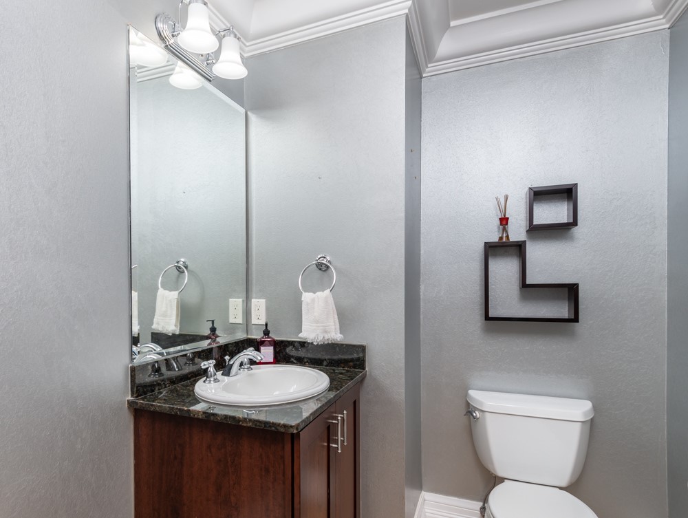 2240 Front Street, Unit 103 Melbourne, FL 32901 - Photo 12 of 31 a bathroom with a toilet sink and mirror