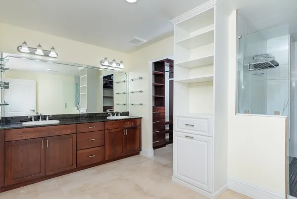 a spacious bathroom with a double vanity sink a large mirror and a shower