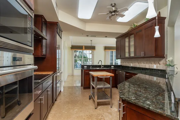 a kitchen with stainless steel appliances granite countertop a stove a sink and a refrigerator