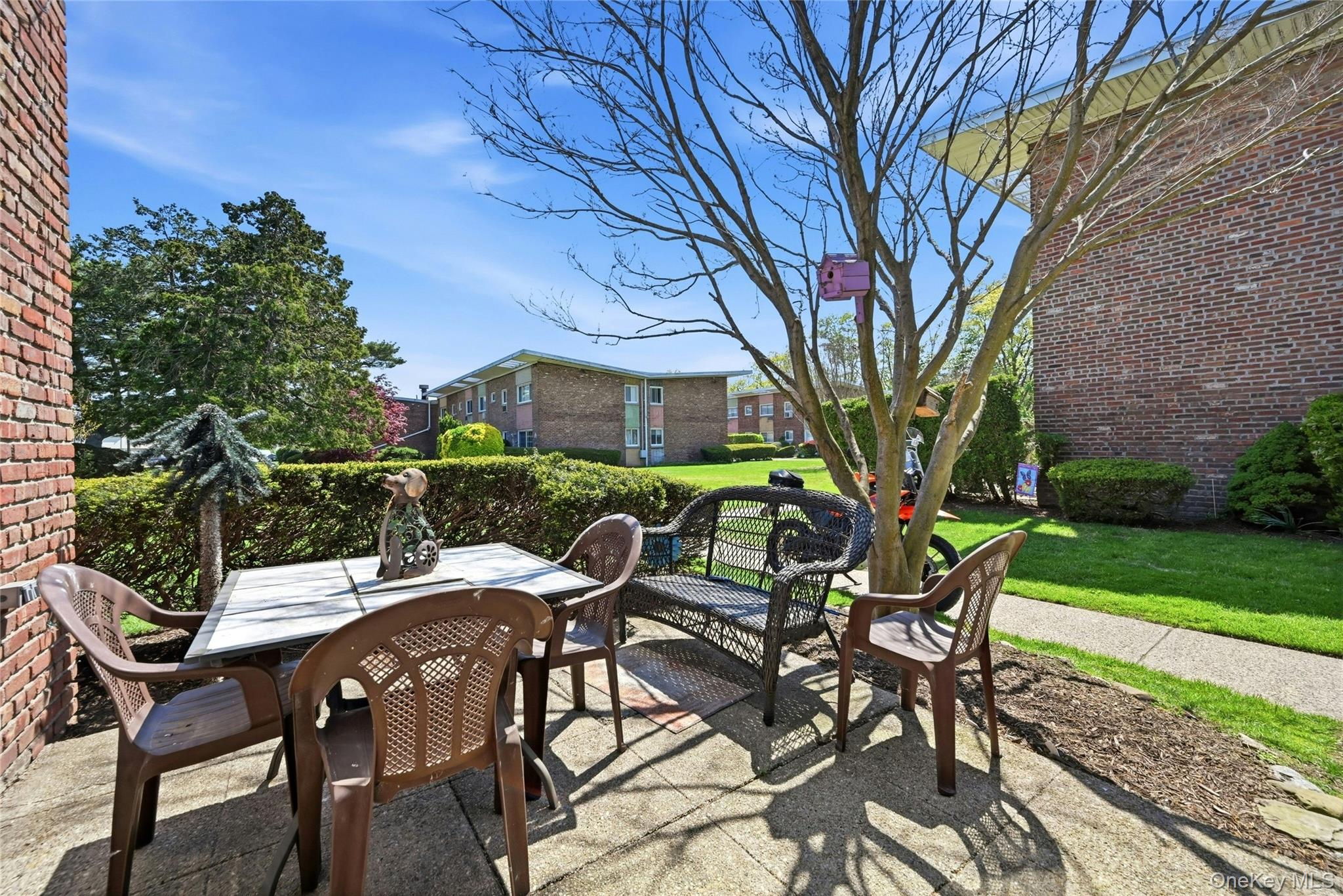 263 North Newbridge Road, Unit 1C Levittown, NY 11756 - Photo 11 of 19 a view of a patio with table and chairs under an umbrella with wooden fence