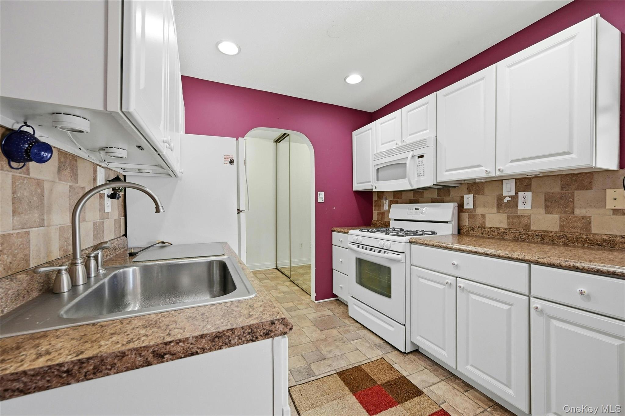 263 North Newbridge Road, Unit 1C Levittown, NY 11756 - Photo 14 of 19 a kitchen with stainless steel appliances granite countertop a sink and cabinets