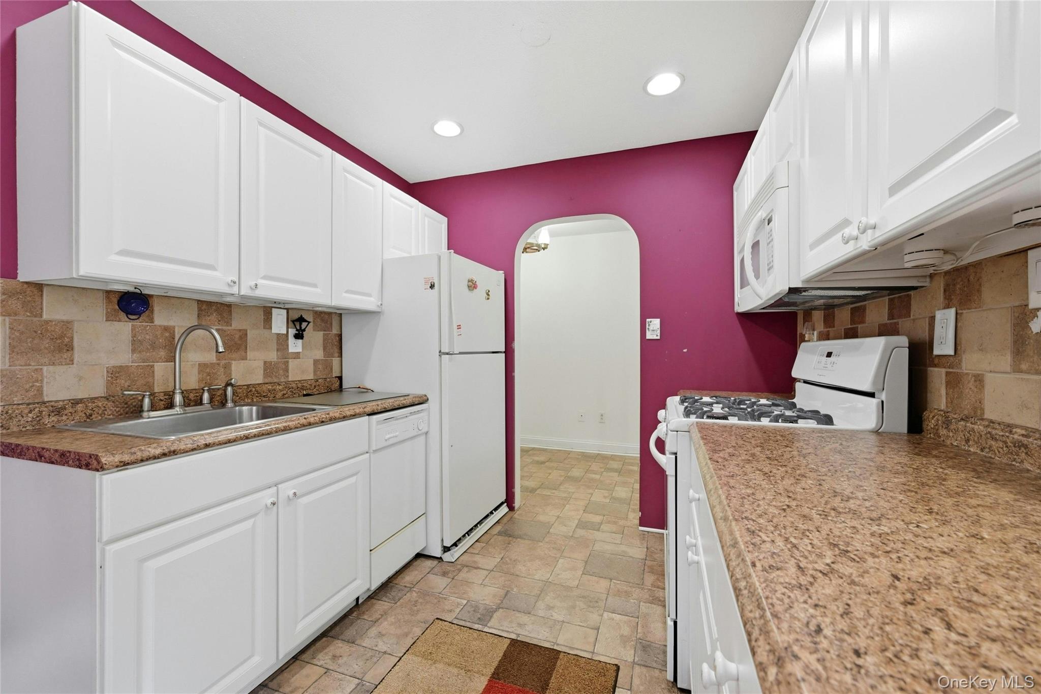 263 North Newbridge Road, Unit 1C Levittown, NY 11756 - Photo 15 of 19 a kitchen with stainless steel appliances granite countertop a stove a sink and a microwave