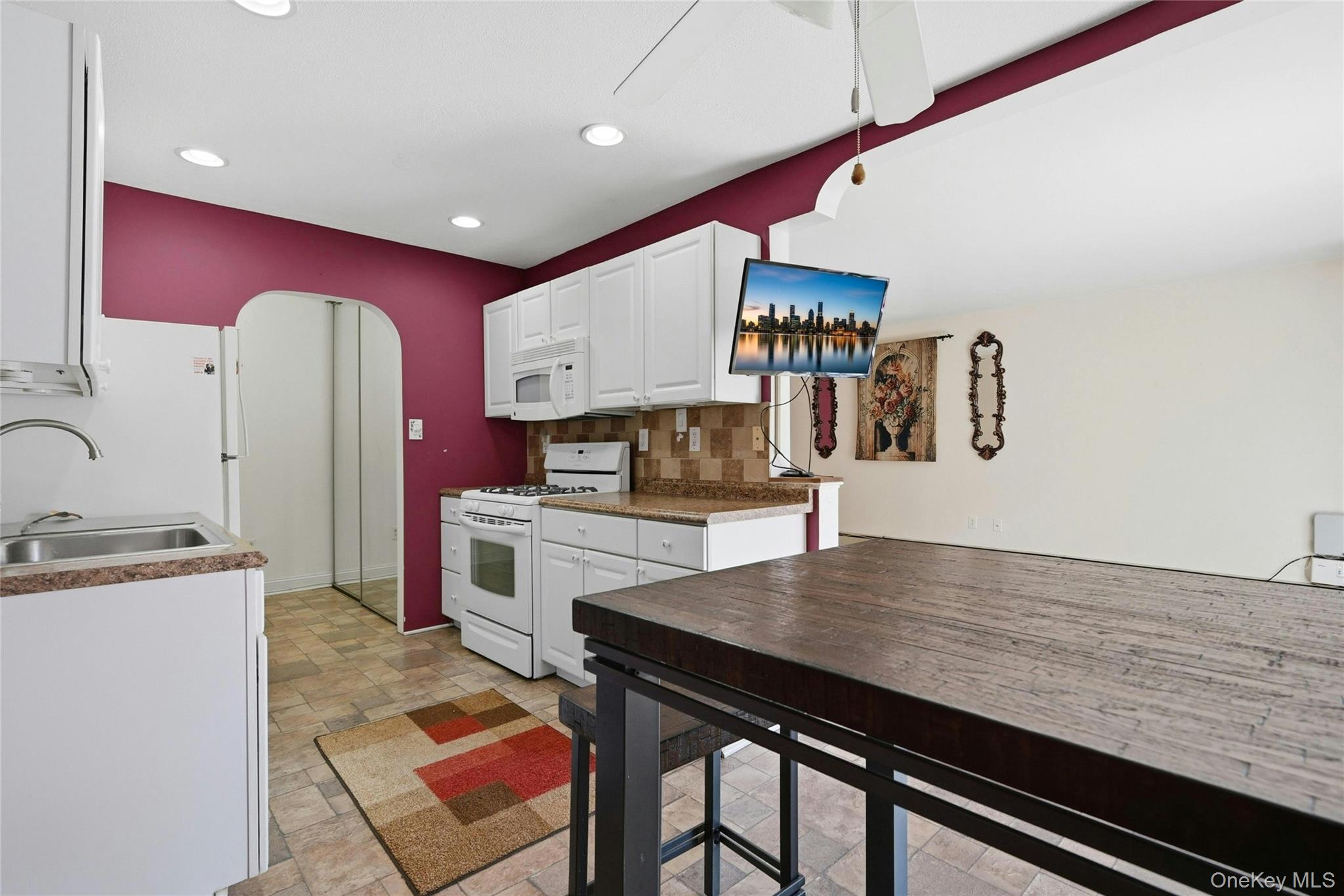 263 North Newbridge Road, Unit 1C Levittown, NY 11756 - Photo 16 of 19 a kitchen with stainless steel appliances granite countertop a stove a sink and a refrigerator