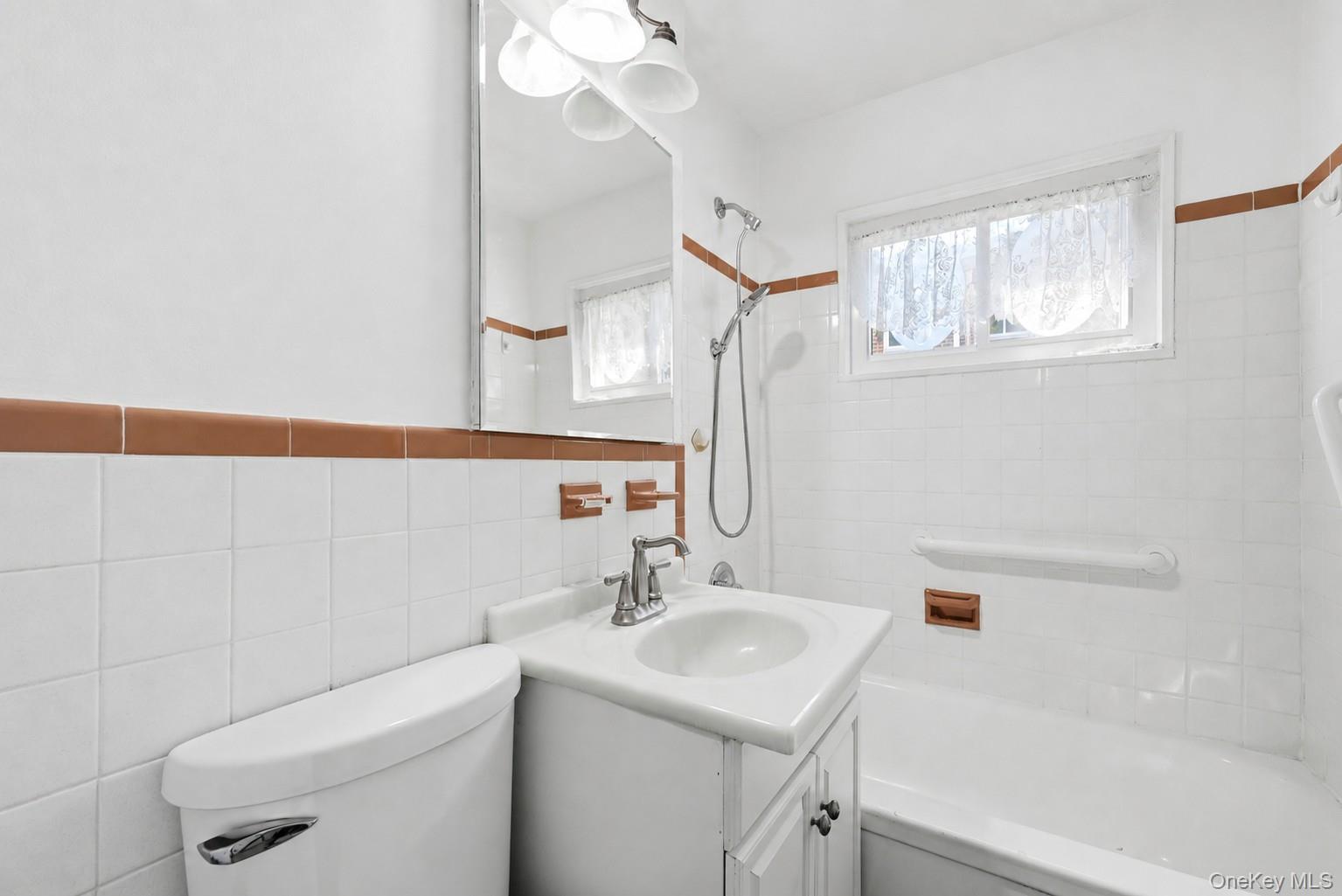 263 North Newbridge Road, Unit 1C Levittown, NY 11756 - Photo 17 of 19 a bathroom with a sink a toilet and a bathtub