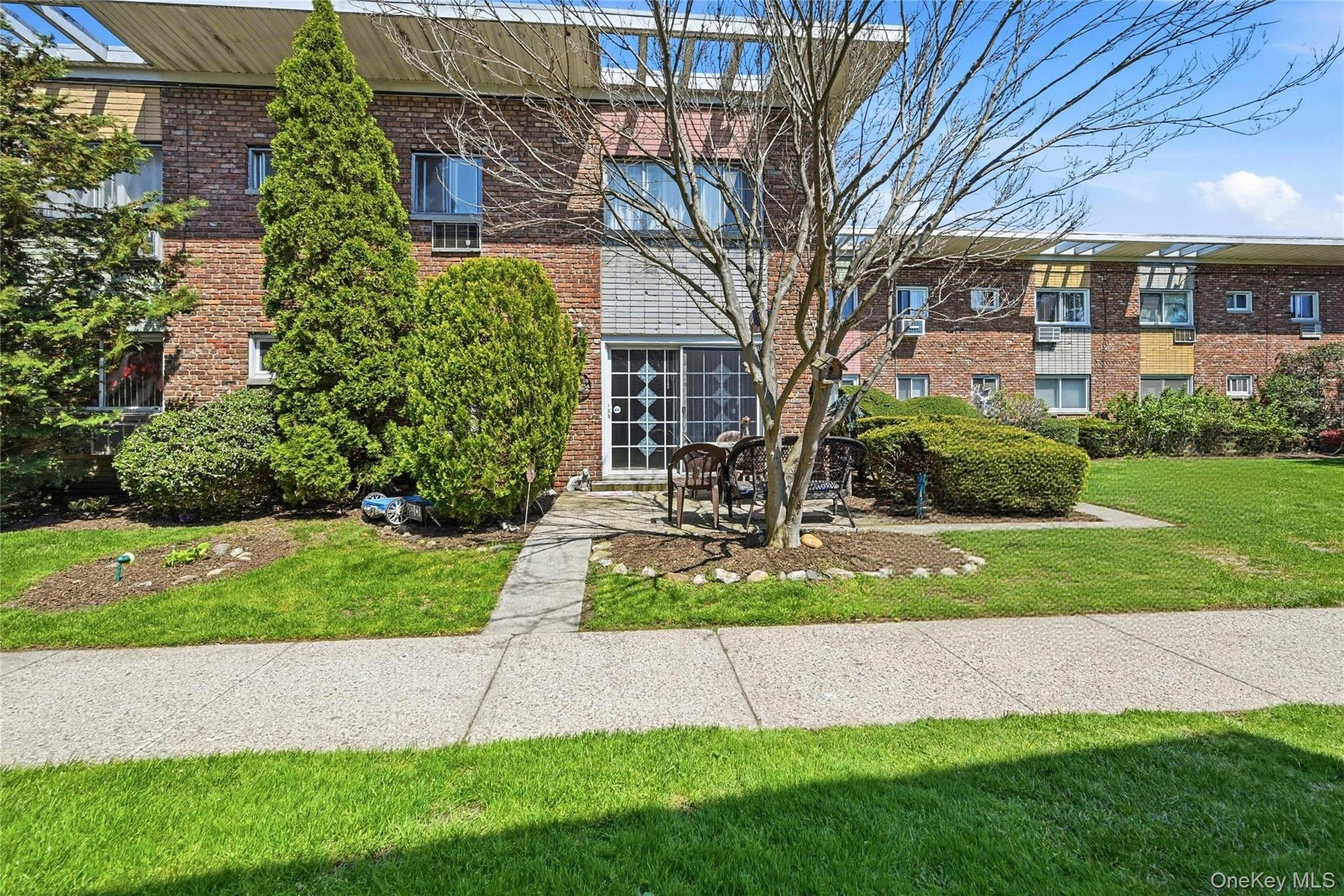 263 North Newbridge Road, Unit 1C Levittown, NY 11756 - Photo 18 of 19 a front view of a house with a yard