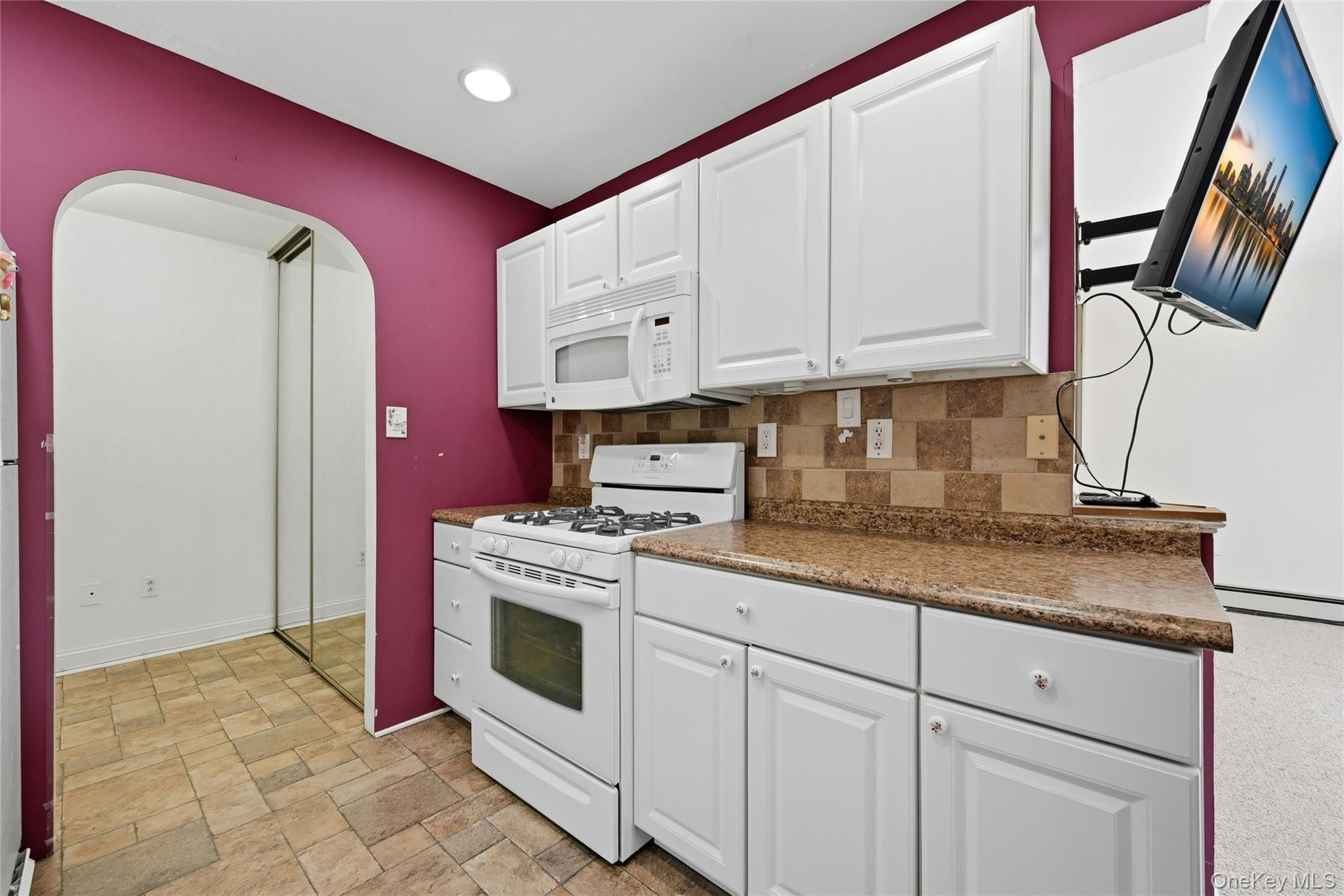 263 North Newbridge Road, Unit 1C Levittown, NY 11756 - Photo 8 of 19 a kitchen with granite countertop a stove sink and cabinets