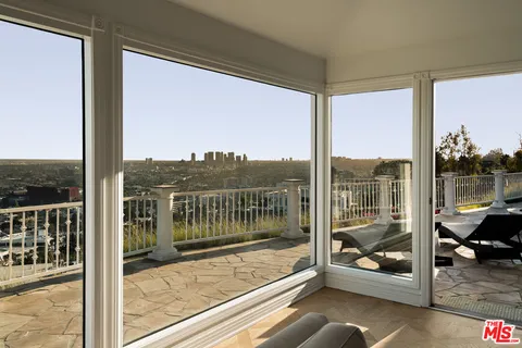 a living room with furniture tv and a floor to ceiling window