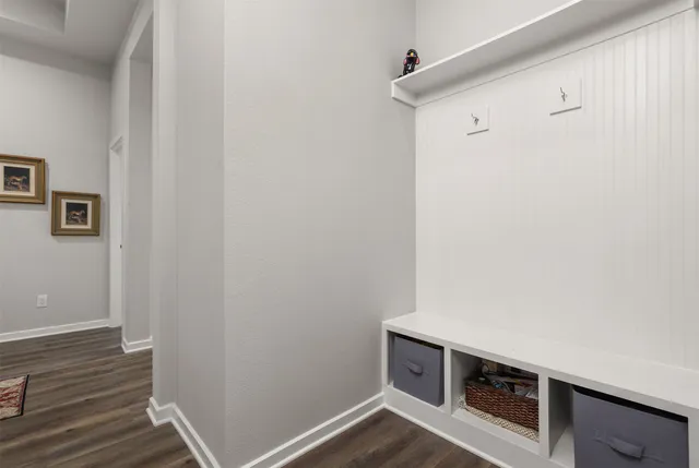 a kitchen with kitchen island granite countertop a refrigerator a stove a sink and white cabinets with wooden floor