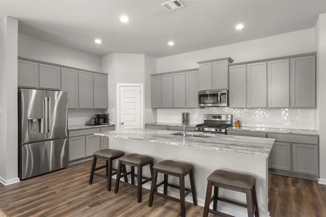 a kitchen with stainless steel appliances granite countertop a sink stove and refrigerator
