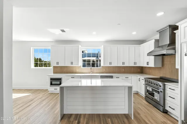 a view of a hallway with wooden floor and entryway