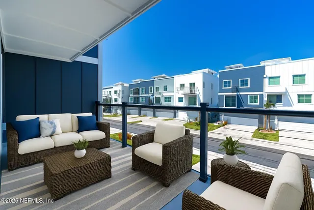 a view of a balcony with chairs and wooden floor