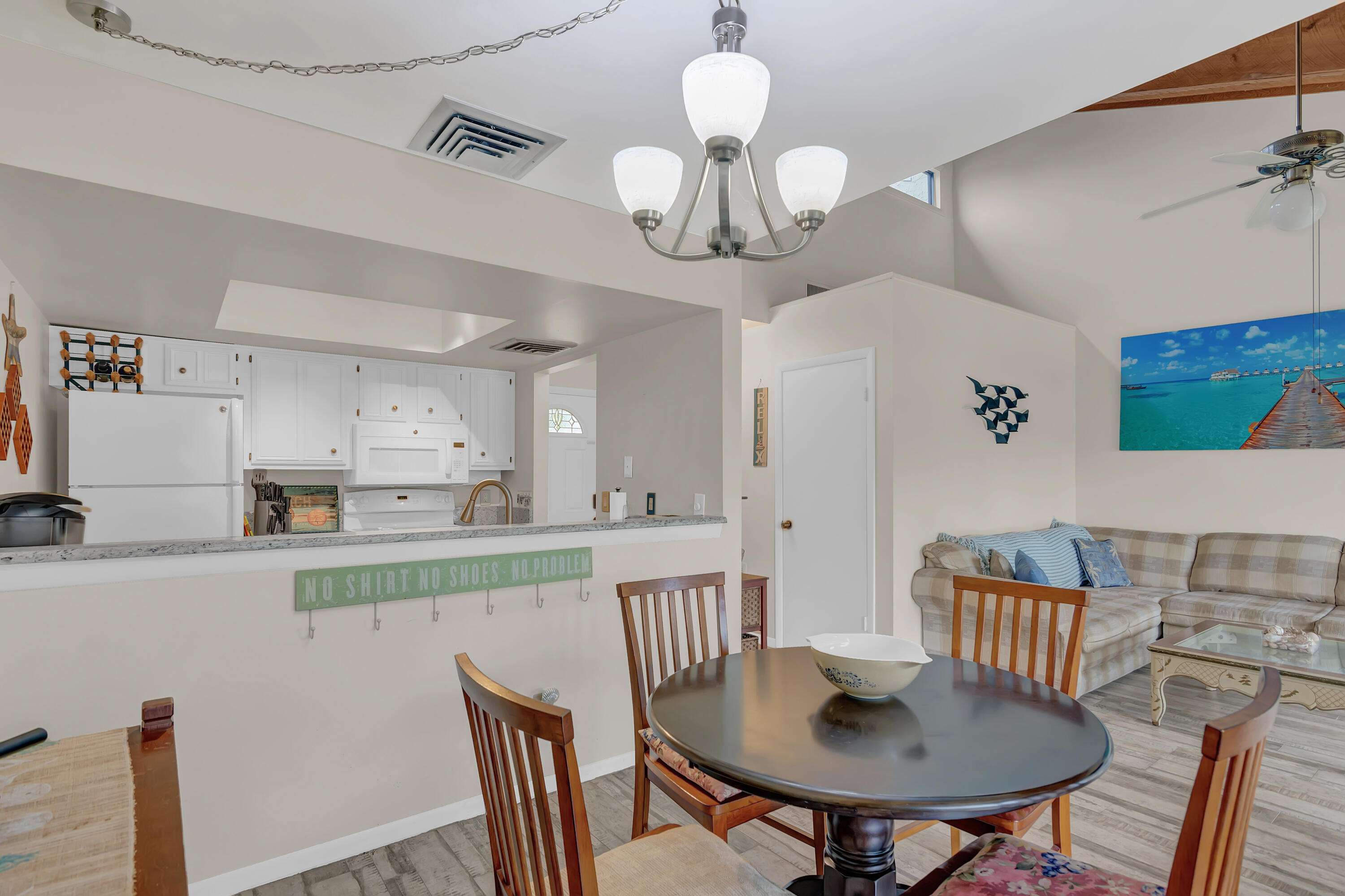 2400 South Ocean Drive, Unit 1122 Fort Pierce, FL 34949 - Photo 11 of 18 a kitchen with stainless steel appliances granite countertop a dining table chairs and a microwave