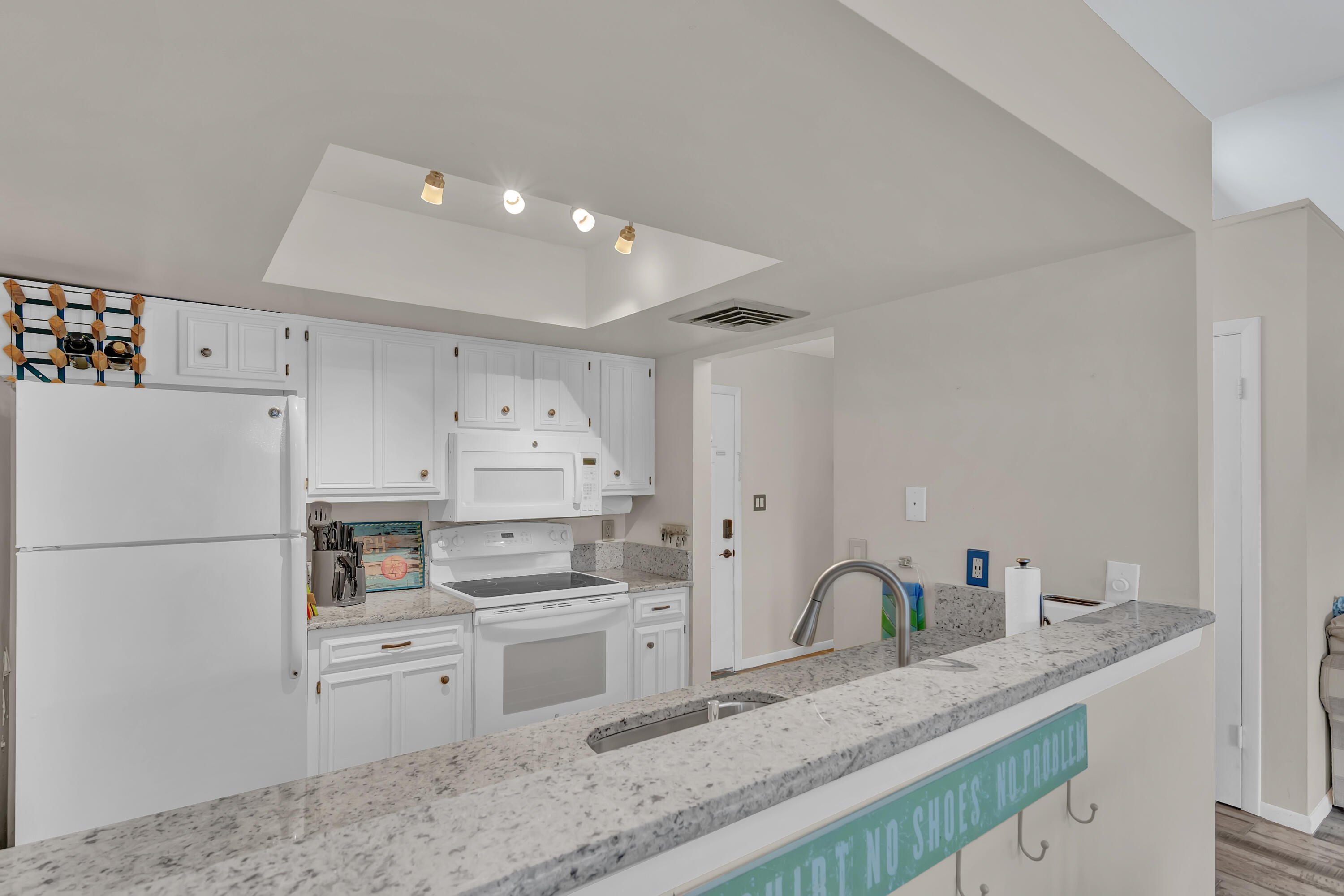 2400 South Ocean Drive, Unit 1122 Fort Pierce, FL 34949 - Photo 10 of 18 a kitchen with granite countertop a sink stainless steel appliances and white cabinets