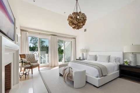 a bedroom with a bed and a chandelier