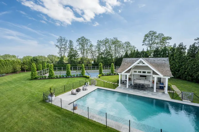 a view of a house with swimming pool next to a yard
