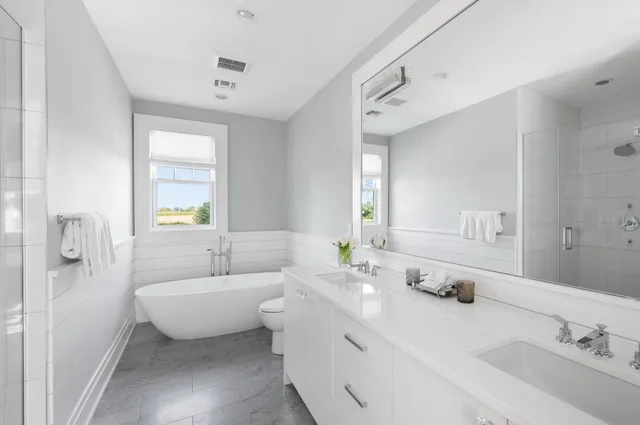 a spacious bathroom with double vanity and a mirror