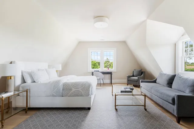 a bedroom with furniture and a large window
