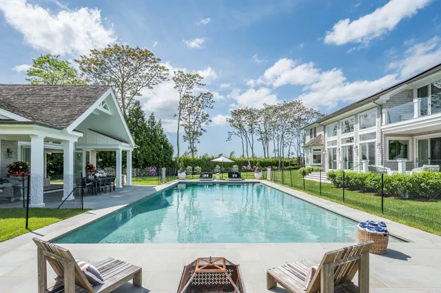 a view of a house with pool and chairs