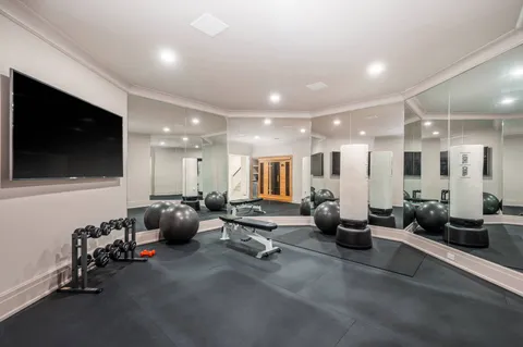 a room with gym equipment and a large mirror