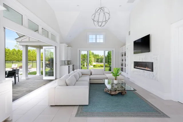 a living room with furniture a flat screen tv and a large window