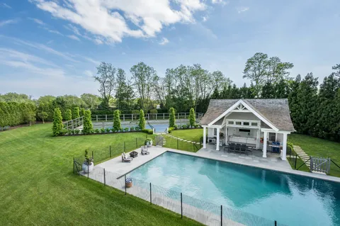 a view of a house with swimming pool next to a yard