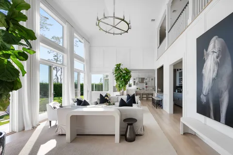 a living room with furniture fireplace and large windows
