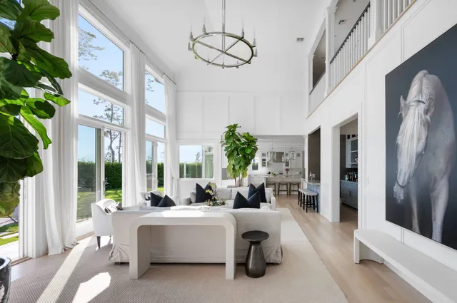 a living room with furniture fireplace and large windows