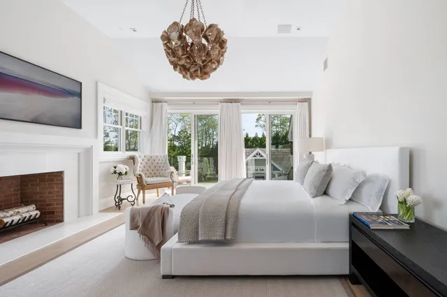 a bedroom with a bed a flat screen tv and a fireplace