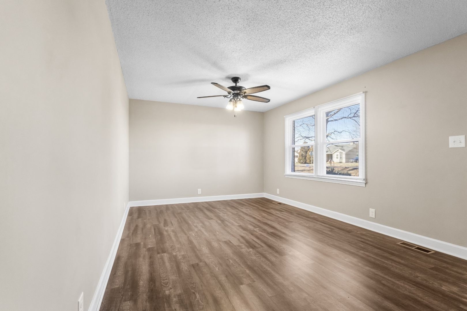118 Union Hall Road Clarksville, TN 37040 - Photo 4 of 26 an empty room with wooden floor ceiling fan and windows