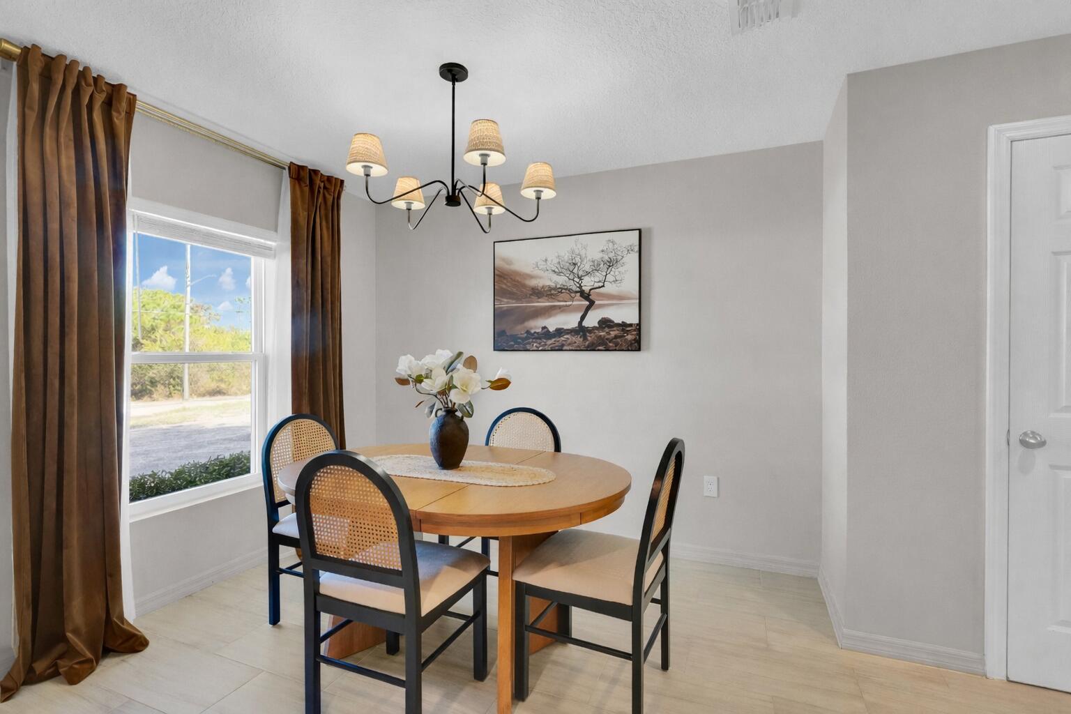 1382 Southwest Becker Road Port St. Lucie, FL 34953 - Photo 14 of 56 a view of a dining room with furniture wooden floor and chandelier