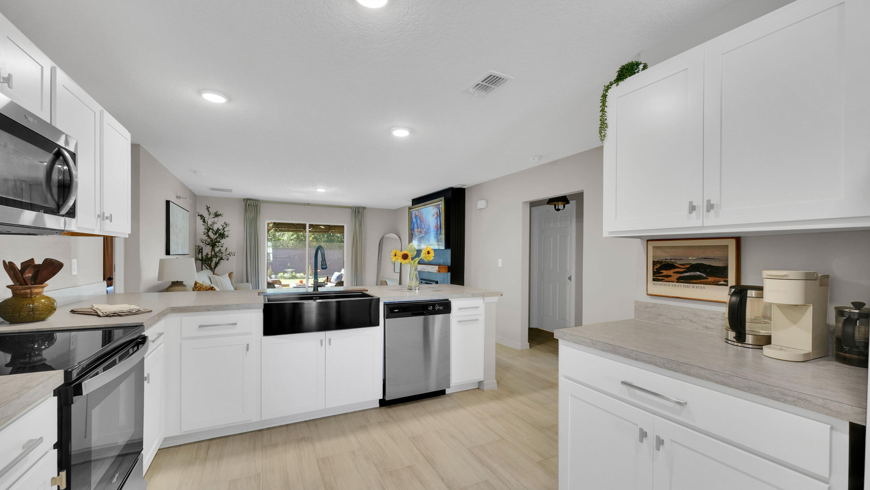 1382 Southwest Becker Road Port St. Lucie, FL 34953 - Photo 17 of 56 a kitchen with stainless steel appliances a sink a stove a microwave a refrigerator a sink and cabinets