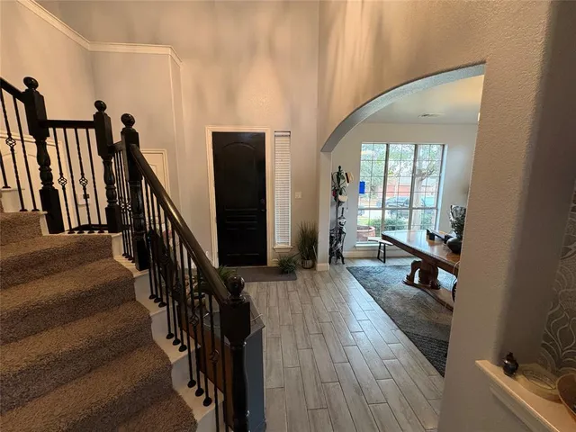 an entryway with wooden floor and stairs