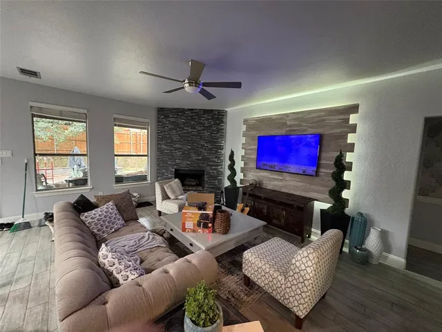 a living room with furniture a flat screen tv and a fireplace