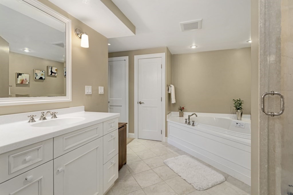 81 Algonquin Road, Unit 81 Newton, MA 02467 - Photo 23 of 40 a spacious bathroom with a tub sink double vanity and mirrors