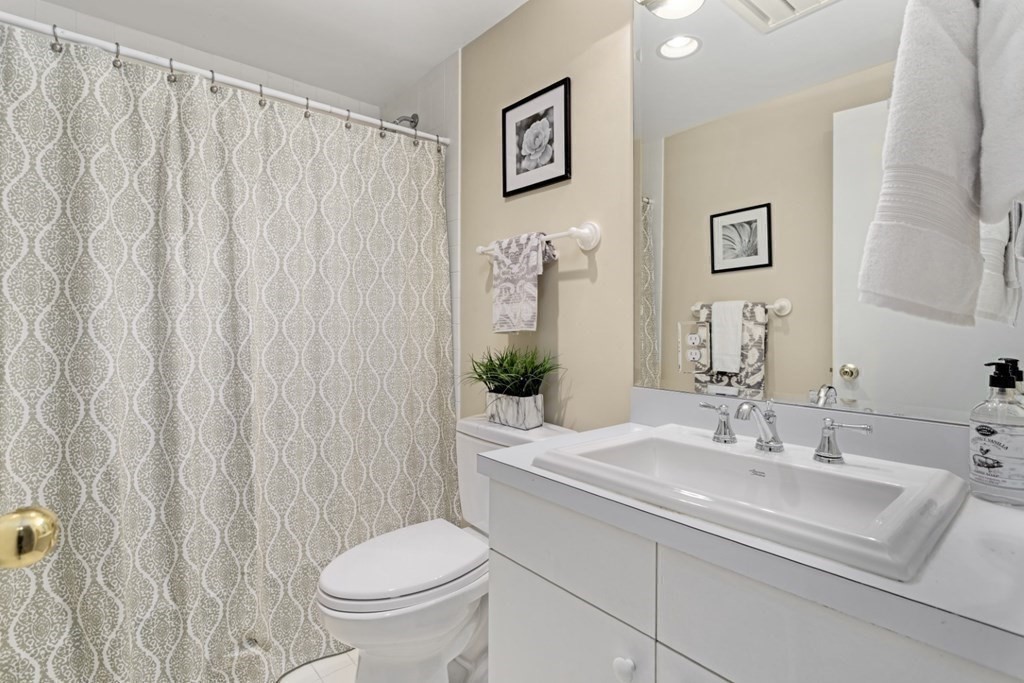 81 Algonquin Road, Unit 81 Newton, MA 02467 - Photo 27 of 40 a bathroom with a granite countertop sink toilet and a mirror