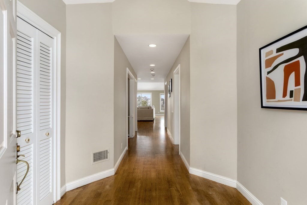 81 Algonquin Road, Unit 81 Newton, MA 02467 - Photo 9 of 40 a view of a hallway with wooden floor and a bathroom