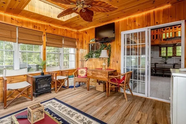 a living room with furniture stove and large window