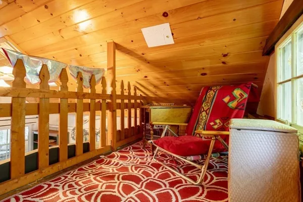 a living room with furniture a rug and a floor to ceiling window