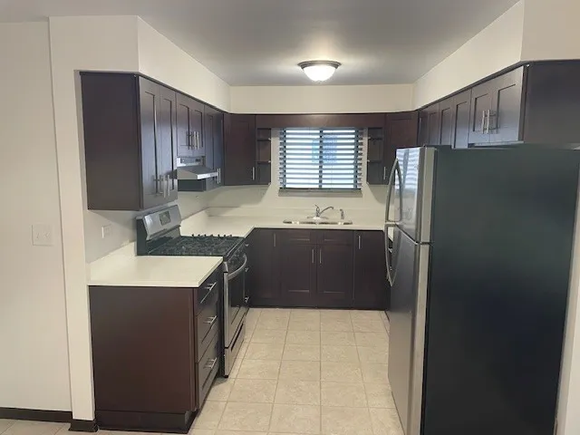 a kitchen with stainless steel appliances granite countertop a refrigerator and a sink