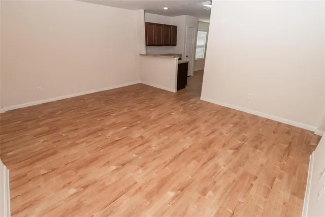 a view of a room with wooden floor and mirror
