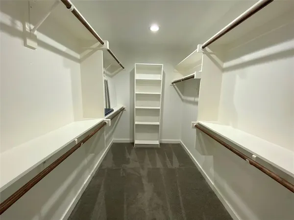 an empty room with chandelier fan and windows