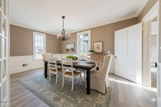 a dining room with furniture window and wooden floor