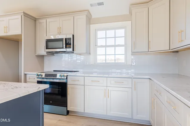 a kitchen with white cabinets and a stove