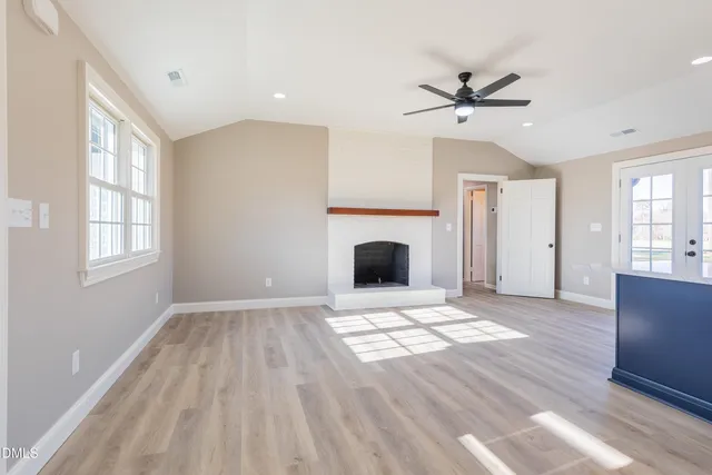 a view of an empty room with a fireplace and a window