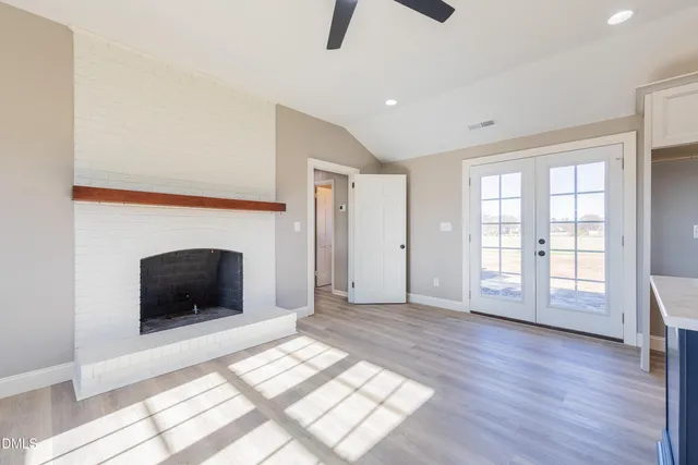 a view of an empty room with window and fire place