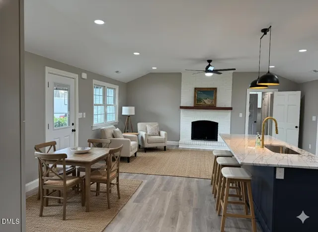a living room with furniture a fireplace and a table